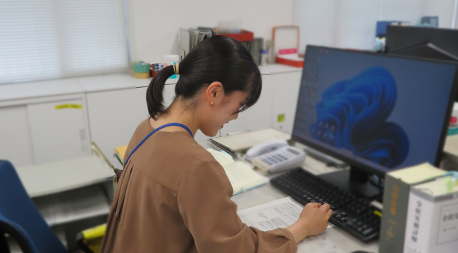 O事務官がデスクで作業する様子