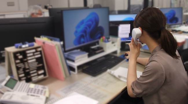 デスクで電話対応をする様子